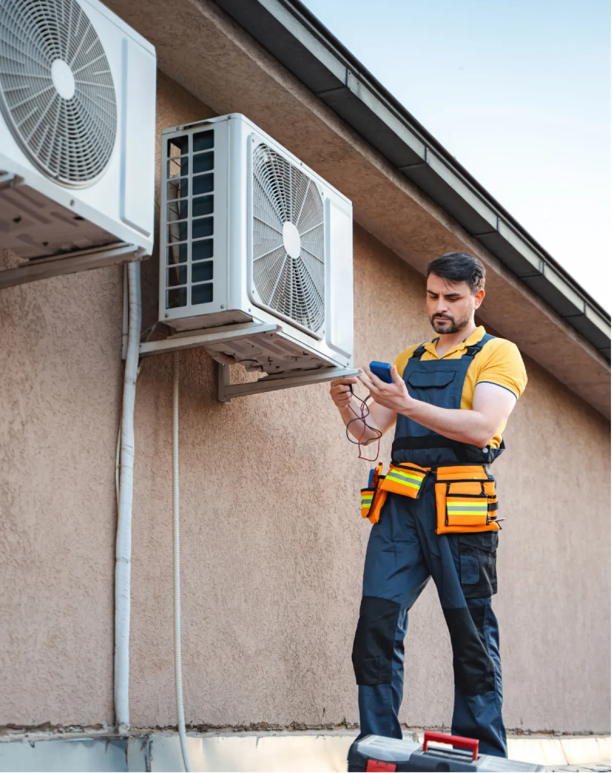 ac-1 A technician in uniform checks an outdoor air conditioning unit with diagnostic tools.